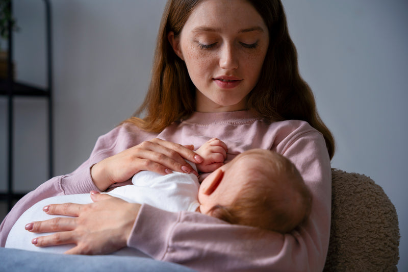 Mutter gibt Muttermilch an süsses Neugeborenes